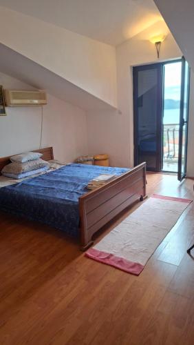 a bedroom with a large bed with a blue comforter at Natalia Rooms Old Town in Herceg-Novi