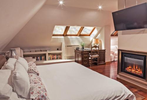 a bedroom with a large bed and a fireplace at Cubo's Casa Liso in Coaña