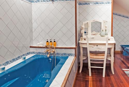 a bathroom with a tub with a table and a sink at Cubo's Casa Liso in Coaña