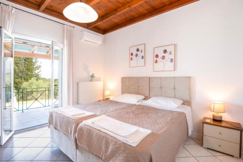 a bedroom with a large bed and a balcony at Villa ChrisDina in Nýmfai