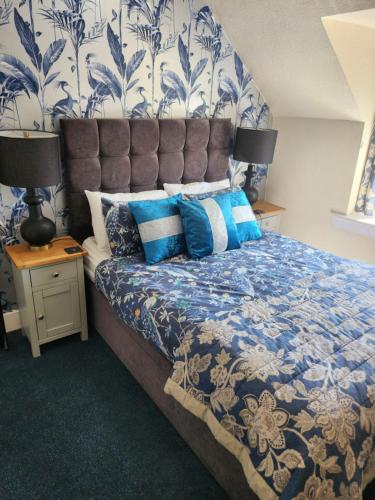a bedroom with a bed with a blue and white comforter at No 27 in Inverness