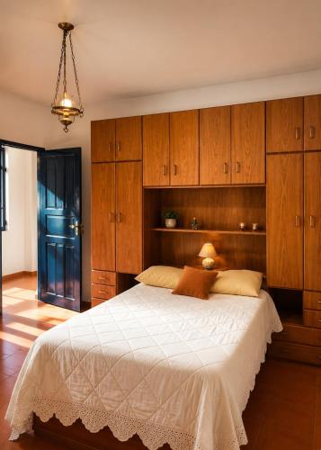 a bedroom with a large bed with wooden cabinets at Sítio São Roque in São Roque