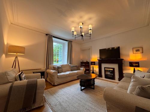 a living room with a couch and a fireplace at Glenrigh House - Main Residence for 7 people in Onich