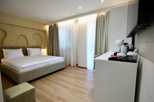 a bedroom with a bed and a table in a room at Andorini Hotel in Finiq