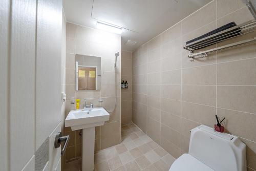 a bathroom with a white toilet and a sink at Visitor guesthouse in Jeju