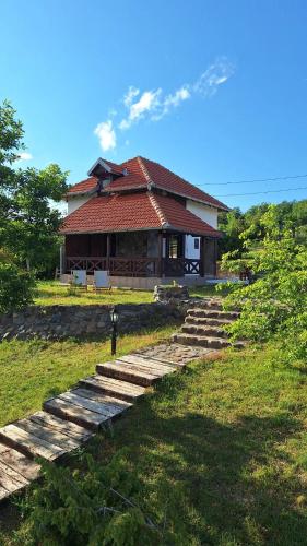 a house with stairs leading up to a house at Planinska kuća Radulović in Goč