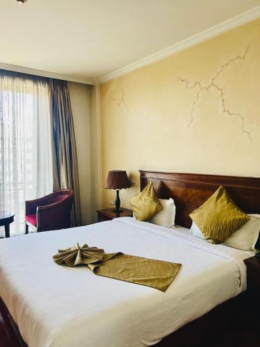 a hotel room with a large bed with gold pillows at Foyat Hotel in Addis Ababa