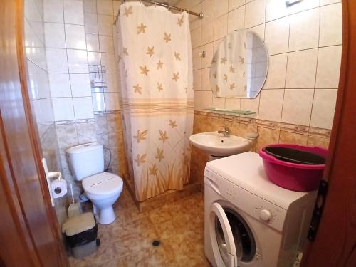 a bathroom with a washing machine and a sink at Guest House Olimpiya in Sveti Vlas