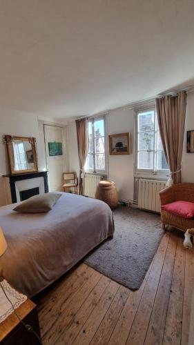 a bedroom with a large bed and two windows at La Bonne Etoile, près Giverny in Vernon