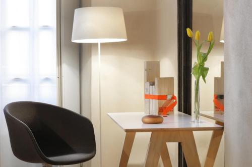 a black chair sitting next to a table with a lamp at Hotel Palazzo Grillo in Genova