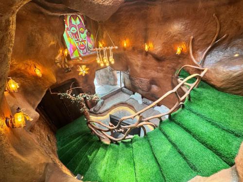 an overhead view of a staircase in a room with green grass at Rai’s Coorg Cave House in Madikeri