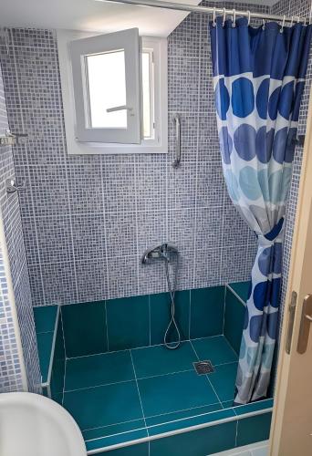 a bathroom with a shower with blue tiles at Relaxing home 80m from the sea in Perea