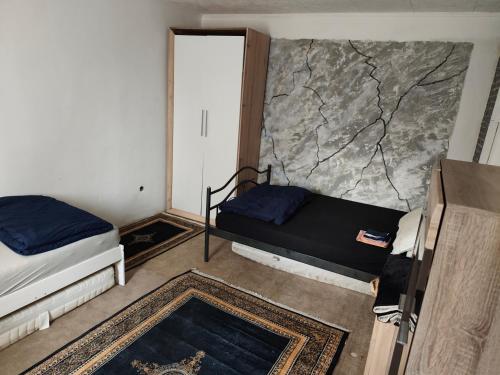 ein Zimmer mit zwei Betten und einer Steinwand in der Unterkunft imperial 2 in Leuenberg