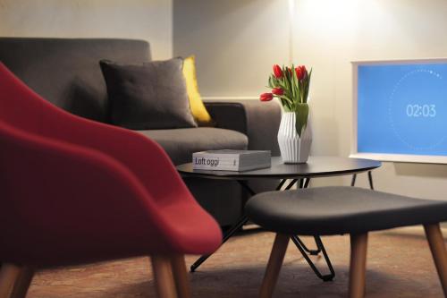 a living room with a couch and a table with a vase of flowers at Hotel Palazzo Grillo in Genova