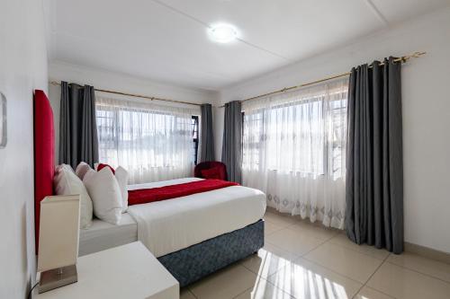 a hotel room with a bed and windows at Safi Luxury Apartment 6 - 2 bedroom in East London
