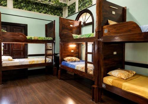 a room with three bunk beds in a house at Hostel Museo Relic in Panama City