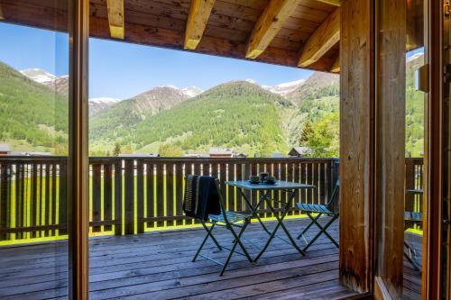 a view from the deck of a cabin with a table and chairs at Ferienwohnung Aegimatte in Ulrichen