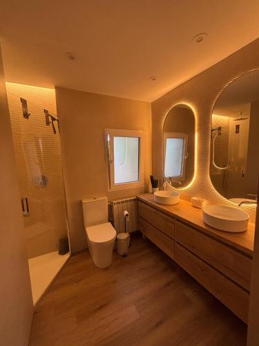 a bathroom with two sinks and a toilet and a tub at Villa Mar in Teià