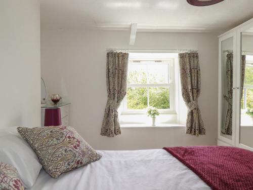 a bedroom with a bed and a window at Gwynn Cottage in Bodmin