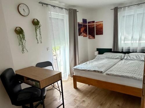 a bedroom with a bed and a desk and a clock at Puzzle Haus in Gyenesdiás