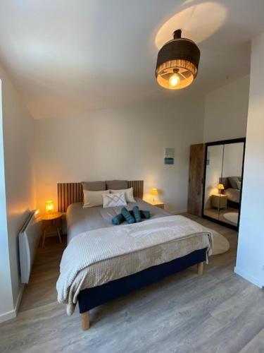 a bedroom with a large bed and a lamp at Escapade cosy - Sauternes & Château à pied in Villandraut