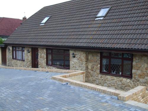 a stone house with a brown roof and a driveway at Bed & Breakfast Fieldview in Rochester
