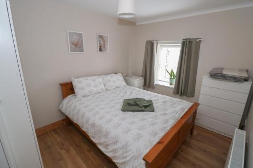 a small bedroom with a bed and a window at Tí Maolla in Hollymount