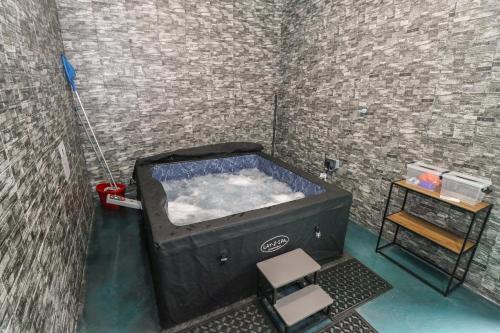 a room with a tub with a chair and a table at Tí Maolla in Hollymount