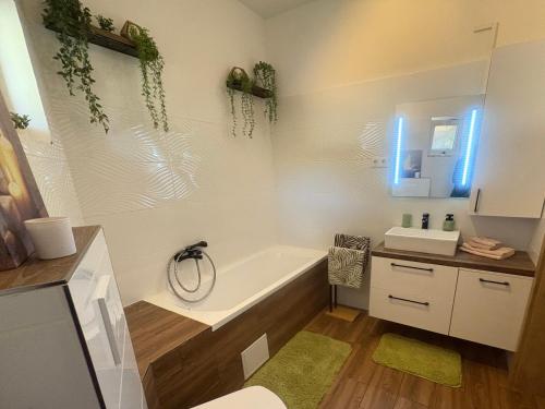 a bathroom with a tub and a sink and a mirror at Puzzle Haus in Gyenesdiás