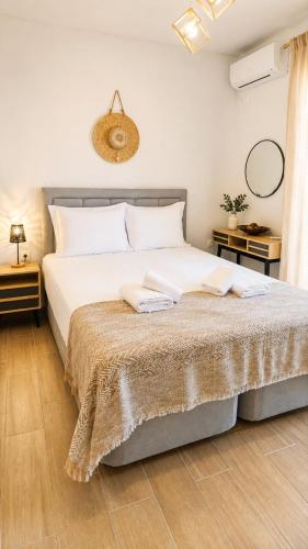 a bedroom with a large white bed with two tables at Athinais Karystos in Karistos