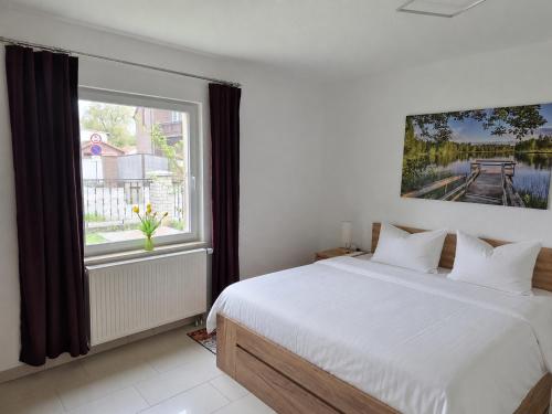 a bedroom with a large white bed and a window at Zum alten Hafen Wesenberg in Wesenberg