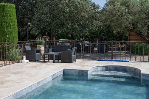 a swimming pool with chairs and a table in a yard at chambre d'hotes les cigales in Comps