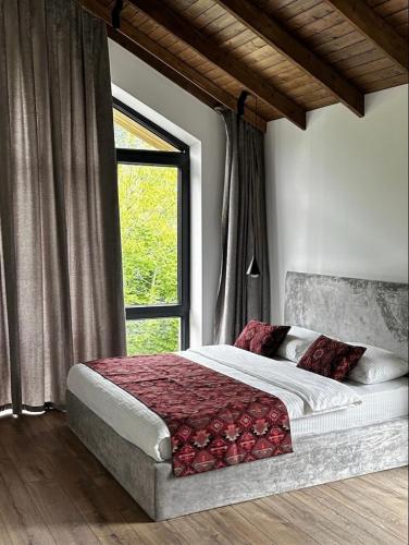 a bedroom with a large bed with a window at escape gabala in Vǝndam