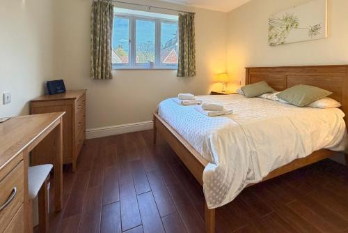 a bedroom with a large bed and a window at Cottages by the Moat in Hassocks