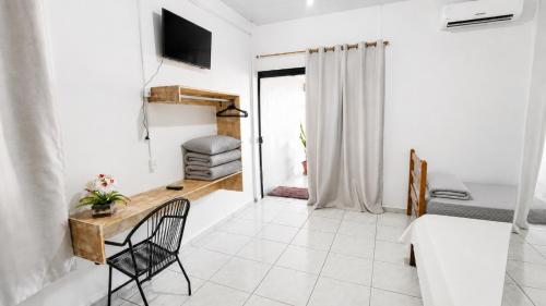 a bedroom with a desk and a bed and a television at Estádia aconchegante! in Vilhena