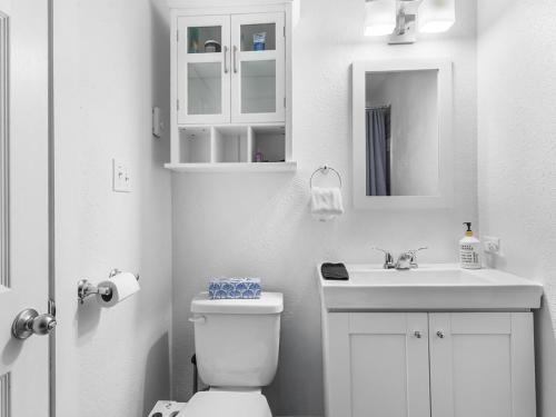 a white bathroom with a toilet and a sink at Mountain Edge 1020 our Holiday Home in Kimberley