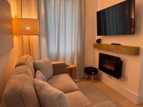 ein Wohnzimmer mit Sofa und Kamin in der Unterkunft Glenrigh House - Loch View Flat for 2 in Onich