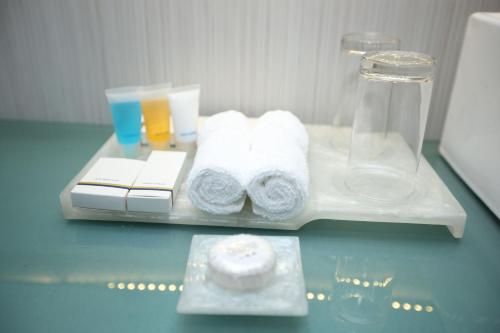 a tray with towels and glasses on a table at Blossom Hotel Dhaka in Dhaka