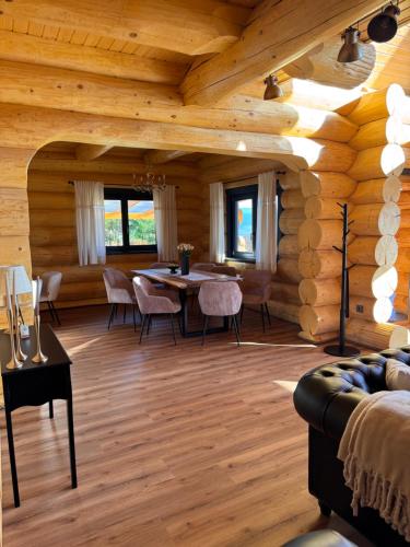 a dining room with a table in a log cabin at Chalet Marilyn in Topliţa