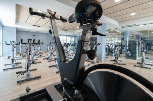 a gym with rows of treadmills and ellipticals at Hotel Sorli Emocions in Vilassar de Dalt