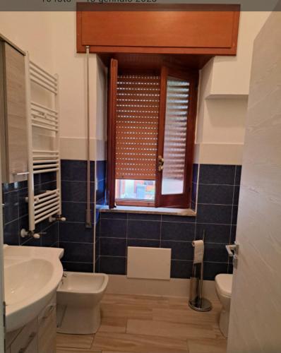 a bathroom with a sink and a toilet and a window at La casa rossa in Siderno Marina