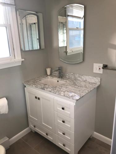 a bathroom with a sink and a mirror at Pet-Friendly Private Beach Oceanfront Cottage in Charlestown