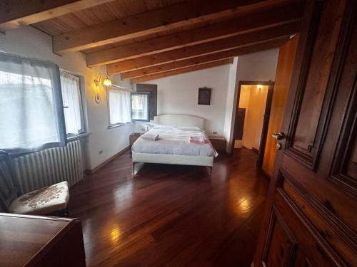 a bedroom with a bed in a room with wooden floors at La Magnolia in Magenta