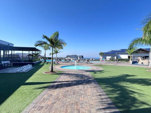 a park with a fountain in the middle of a park with palm trees at Onyx Oasis in Ballito