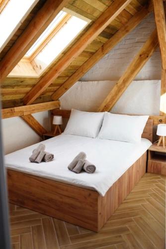 a bedroom with a bed with two slippers on it at Przystań Jeziorna in Pasym