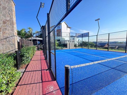 a tennis court with a net on top of it at Shoreline Sanctuary! in Ballito