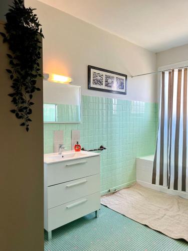 a bathroom with a sink and a bath tub at Maison familiale champêtre 8 pers in Fontet