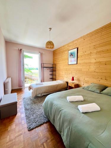 a bedroom with two beds and a large window at Maison familiale champêtre 8 pers in Fontet