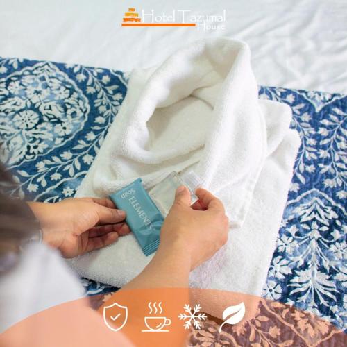a person holding a thermometer next to a towel at Hotel Tazumal House in San Salvador