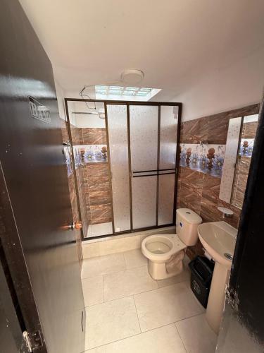 a bathroom with a toilet and a sink at Hostal Brooklyn in Ipiales
